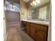 Bathroom vanity with wood cabinets, and mirror with decorative lighting adjacent to an open-concept bedroom at 608 Fairhaven Blvd, Stockbridge, GA 30281