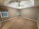 Bedroom with neutral walls, plush carpet, tray ceiling, and natural light from two windows at 608 Fairhaven Blvd, Stockbridge, GA 30281
