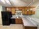Kitchen featuring wood cabinetry, gray countertops, and modern appliances with a breakfast bar at 608 Fairhaven Blvd, Stockbridge, GA 30281
