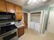 Kitchen featuring stainless appliances, wood cabinets, and adjacent laundry closet at 608 Fairhaven Blvd, Stockbridge, GA 30281