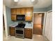 Kitchen featuring a stainless steel oven, wood cabinets, and view into living space at 608 Fairhaven Blvd, Stockbridge, GA 30281