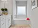 This bright bathroom features a soaking tub, white cabinets, and neutral colored walls at 14 Jacobs Farm Ln # 7, Lawrenceville, GA 30045