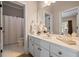 Well-lit bathroom featuring white cabinets and a large vanity mirror at 1409 Spyglass Hill Dr, Johns Creek, GA 30097