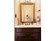 Elegant powder room boasts decorative mirror, dark wood vanity, and neutral color palette at 1409 Spyglass Hill Dr, Johns Creek, GA 30097