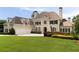 Grand home with a three-car garage, manicured lawn, and elegant landscaping at 1409 Spyglass Hill Dr, Johns Creek, GA 30097