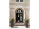 Ornate front door with decorative glass, flanked by potted flowers at 1409 Spyglass Hill Dr, Johns Creek, GA 30097