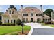 Elegant home with manicured lawn, circular driveway, and classic architectural details at 1409 Spyglass Hill Dr, Johns Creek, GA 30097