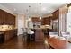 Open concept kitchen with central island, granite countertops and dark wood cabinetry at 1409 Spyglass Hill Dr, Johns Creek, GA 30097