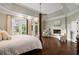 Bright main bedroom with hardwood floors, fireplace, sitting area, and french doors leading to the outside at 1409 Spyglass Hill Dr, Johns Creek, GA 30097