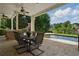 Covered patio area with dining table overlooking the sparkling swimming pool at 1409 Spyglass Hill Dr, Johns Creek, GA 30097