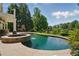 Inviting backyard with a swimming pool, spa, and outdoor brick fireplace at 1409 Spyglass Hill Dr, Johns Creek, GA 30097