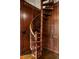Detailed view of a classic wooden spiral staircase with paneled walls and hardwood floors at 1409 Spyglass Hill Dr, Johns Creek, GA 30097