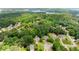 Scenic aerial view of houses nestled among lush trees, with a glimpse of a serene lake in the distance at 3040 Larkspur Ct, Cumming, GA 30041