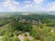 Community aerial view displaying homes surrounded by a canopy of lush trees, featuring a lake in the distance at 3040 Larkspur Ct, Cumming, GA 30041