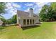 Well-manicured backyard with lush green lawn and white two-story home with a fence and trees at 3040 Larkspur Ct, Cumming, GA 30041