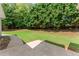 Backyard featuring a concrete walkway extending into the lawn with various trees and landscaping at 3040 Larkspur Ct, Cumming, GA 30041