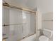 Bright bathroom featuring a shower-tub combo with gold hardware and a white toilet at 3040 Larkspur Ct, Cumming, GA 30041
