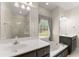 Bright bathroom features a double sink vanity, a soaking tub, and a walk-in shower with glass door at 3040 Larkspur Ct, Cumming, GA 30041