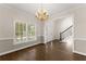 Bright dining room with wood floors, white trim, and a elegant chandelier, offering a view of the staircase at 3040 Larkspur Ct, Cumming, GA 30041