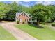 Charming brick home with well-manicured lawn, mature trees, and a welcoming driveway, highlighting curb appeal at 3040 Larkspur Ct, Cumming, GA 30041