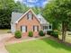 Charming two-story brick home featuring a well-manicured lawn and mature trees, located in a quiet neighborhood at 3040 Larkspur Ct, Cumming, GA 30041