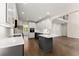 Open kitchen layout with an island, two-tone cabinets, hardwood floors, quartz countertops, and stainless steel appliances at 3040 Larkspur Ct, Cumming, GA 30041