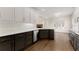 Modern kitchen featuring two-tone cabinetry, quartz countertops, stainless steel appliances, and hardwood floors at 3040 Larkspur Ct, Cumming, GA 30041