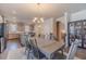 An open-concept dining room featuring a dining table, modern chandelier, and gray cabinets with a view of the staircase at 3080 Westpoint Cir, Snellville, GA 30078