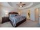 Spacious main bedroom featuring a tray ceiling, ceiling fan, and ensuite bathroom at 3080 Westpoint Cir, Snellville, GA 30078