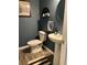 This powder room has a pedestal sink, commode, and decor shelf at 409 Ruths Blvd, Woodstock, GA 30188