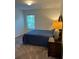 Bedroom featuring a bed with blue bedding, a nightstand, and a window at 409 Ruths Blvd, Woodstock, GA 30188