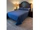 Comfortable bedroom featuring a bed with a blue quilt, wood headboard, and neutral carpet at 409 Ruths Blvd, Woodstock, GA 30188