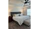 Spacious main bedroom featuring a ceiling fan, neutral decor, and a comfortable upholstered bed at 409 Ruths Blvd, Woodstock, GA 30188