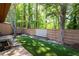 Backyard featuring artificial turf, stone pavers, a wooden fence, and a cozy fire pit for outdoor enjoyment at 845 Lake Hollow Sw Blvd, Marietta, GA 30064