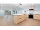 Bright kitchen featuring an island, modern appliances, light wood cabinets, and sliding glass doors to the backyard at 845 Lake Hollow Sw Blvd, Marietta, GA 30064