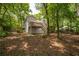 A wooded backyard with a raised deck and staircase is adjacent to a fenced yard at 110 Fairway Ridge Dr, Johns Creek, GA 30022