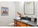 Charming powder room with a black granite countertop, framed mirror, and modern fixtures at 110 Fairway Ridge Dr, Johns Creek, GA 30022