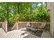 Relaxing outdoor deck with a small table, furniture, and a view of surrounding mature trees at 110 Fairway Ridge Dr, Johns Creek, GA 30022