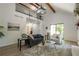 Open-concept living room with vaulted ceiling, wooden beams, black railings, and luxury vinyl plank flooring at 110 Fairway Ridge Dr, Johns Creek, GA 30022