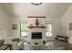 Comfortable living room with a stone fireplace, large windows, vaulted ceilings, and luxury vinyl plank flooring at 110 Fairway Ridge Dr, Johns Creek, GA 30022