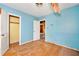 Bedroom with blue walls, wood floors, and an open closet at 2180 Rexford Dr, Decatur, GA 30034