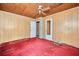 Bedroom featuring dark red carpet, wood paneled walls, and a ceiling fan at 2180 Rexford Dr, Decatur, GA 30034