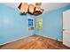 Bedroom showing exposed insulation in the ceiling, light blue walls, and hardwood floors at 2180 Rexford Dr, Decatur, GA 30034