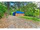 View of a red brick home with tarp, amidst the trees, showcasing potential project and backyard at 2180 Rexford Dr, Decatur, GA 30034