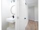 Contemporary half-bath with a wall-mounted sink, modern faucet, and round mirror at 3193 Trasher Cir, Decatur, GA 30032