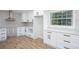 Bright kitchen boasts white cabinets, modern hardware, quartz countertops, and stainless vent hood at 3193 Trasher Cir, Decatur, GA 30032