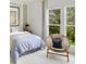 Cozy bedroom with a wicker chair by a bright window, complemented by striped decor at 4815 Ramblewood Dr, Cumming, GA 30028