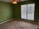 Cozy bedroom featuring a bright window, soft carpet, and a pleasant calming atmosphere at 95 Revere Dr, Fairburn, GA 30213