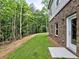 Backyard with brick wall, patio, and a natural wooded area extending beyond the grass at 3730 Reserve Overlook (Lot 8) Way, Cumming, GA 30041