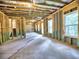 Unfinished basement view with exposed framing and access to outside, offering potential for customization at 3730 Reserve Overlook (Lot 8) Way, Cumming, GA 30041